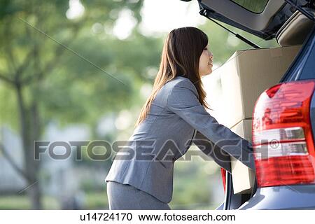 Businesswoman loading cardboard boxes into car View Large Photo Image Stock Image - Businesswoman loading cardboard boxes into car. Fotosearch