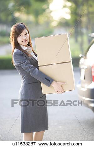 Businesswoman loading cardboard boxes into car View Large Photo Image Stock Photo - Businesswoman loading cardboard boxes into car. Fotosearch