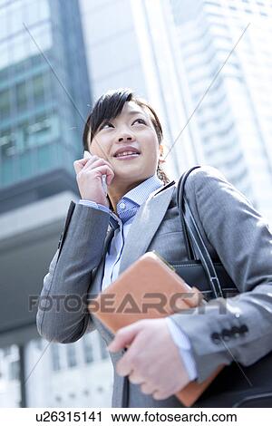 Businesswoman on mobile phone with address book View Large Photo Image Stock Image - Businesswoman on mobile phone with address book. Fotosearch