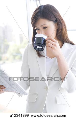 Businesswoman reading newspaper and drinking coffee View Large Photo Image Stock Photo - Businesswoman reading newspaper and drinking coffee. Fotosearch