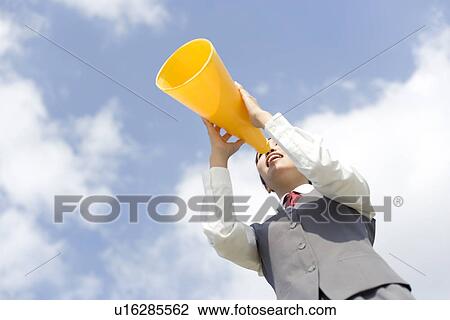 Stock Image - Businesswoman shouting into megaphone. Fotosearch