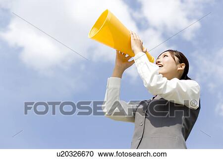 Stock Image - Businesswoman shouting into megaphone. Fotosearch