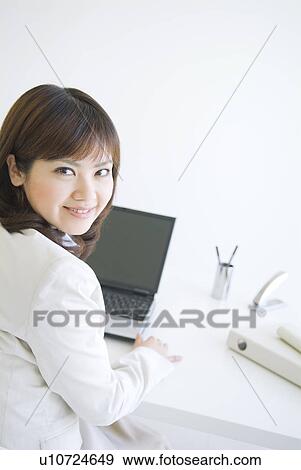 Stock Photo - Businesswoman smiling at the camera. Fotosearch