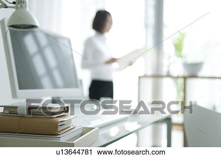 Stock Image - Businesswoman standing in home office. Fotosearch