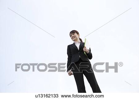 Businesswoman standing with file View Large Photo Image Stock Image - Businesswoman standing with file. Fotosearch
