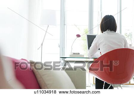 Businesswoman using computer in home office View Large Photo Image Stock Photo - Businesswoman using computer in home office. Fotosearch
