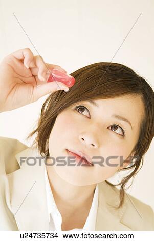 Picture - Businesswoman using eye drops. Fotosearch