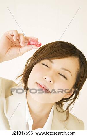 Stock Photograph - Businesswoman using eye drops. Fotosearch