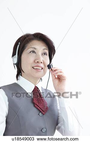 Stock Image - Businesswoman using hands free headset. Fotosearch