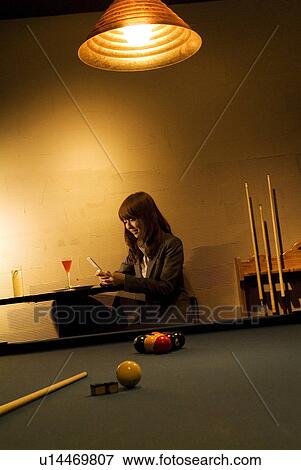 Businesswoman using her phone at a bar View Large Photo Image Stock Photo - Businesswoman using her phone at a bar. Fotosearch