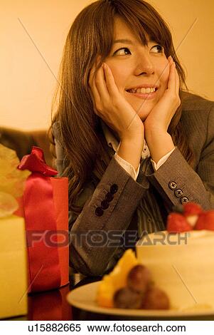 Businesswoman with gifts and a cake in front of her View Large Photo Image Stock Photography - Businesswoman with gifts and a cake in front of her. Fotosearch