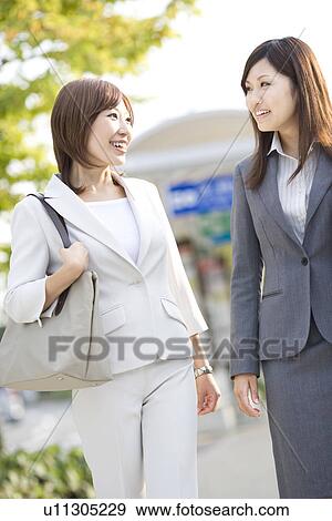 Stock Photo - Businesswomen at bus stop. Fotosearch