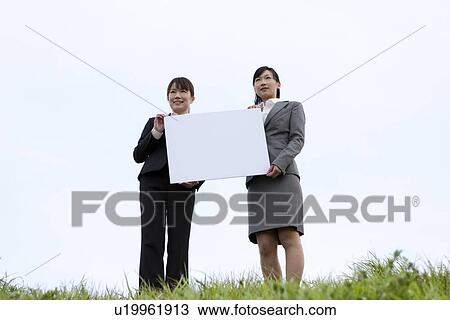 Businesswomen holding message board View Large Photo Image Stock Image - Businesswomen holding message board. Fotosearch
