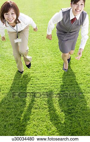 Stock Image - Businesswomen in running race. Fotosearch