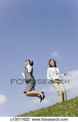 Businesswomen jumping into air View Large Photo Image Stock Image - Businesswomen jumping into air. Fotosearch