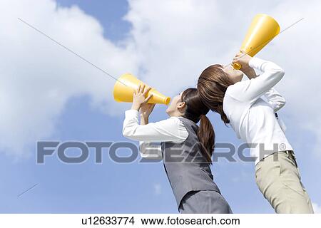 Picture - Businesswomen shouting into megaphone. Fotosearch