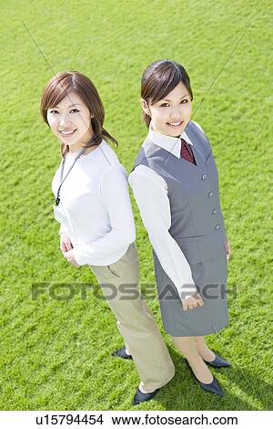 Businesswomen standing on green grass, smiling at the camera View Large Photo Image Picture - Businesswomen standing on green grass, smiling at the camera. Fotosearch