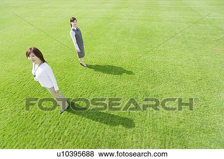 Businesswomen standing on green grass View Large Photo Image Stock Photo - Businesswomen standing on green grass. Fotosearch