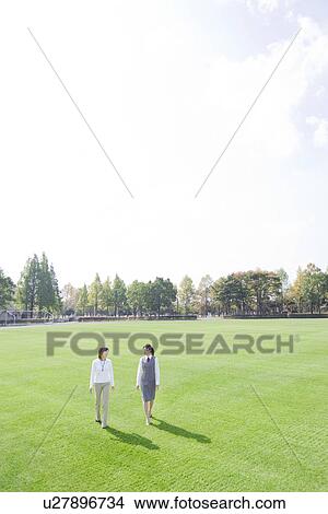 Businesswomen walking in park View Large Photo Image Picture - Businesswomen walking in park. Fotosearch