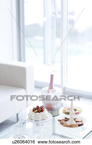 Stock Photograph - Cakestand with cookies, cake and an ice bucket with champagne. Fotosearch