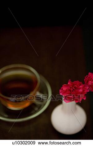 Stock Photo - Carnations in a vase and a cup of tea. Fotosearch