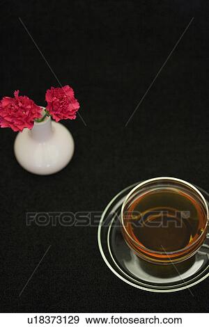 Carnations in a vase and a cup of tea View Large Photo Image Stock Photo - Carnations in a vase and a cup of tea. Fotosearch