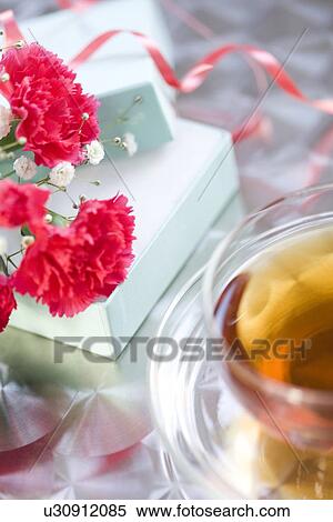 Stock Photography - Carnations with a gift box and a cup of tea. Fotosearch