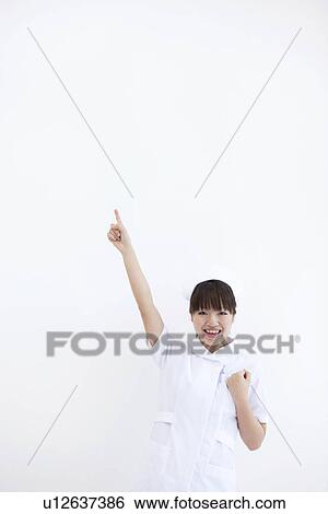 Cheerful nurse pointing finger View Large Photo Image Stock Photograph - Cheerful nurse pointing finger. Fotosearch