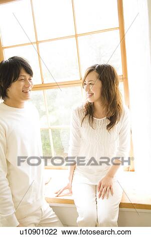 Cheerful woman and man talking near window View Large Photo Image Stock Image - Cheerful woman and man talking near window. Fotosearch