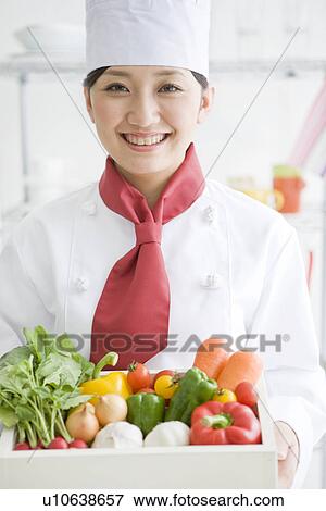 Stock Photo - Chef holding a box of vegetables. Fotosearch