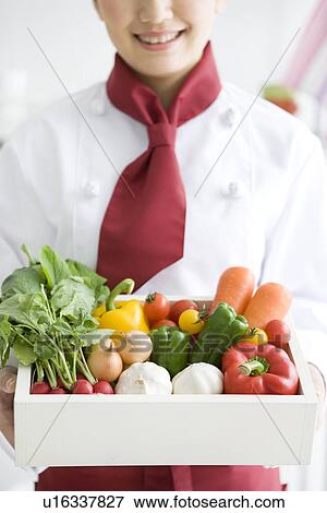 Stock Photo - Chef holding a box of vegetables. Fotosearch