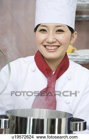 Picture - Chef looking inside pan. Fotosearch