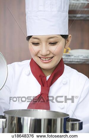 Stock Photograph - Chef looking inside pan. Fotosearch
