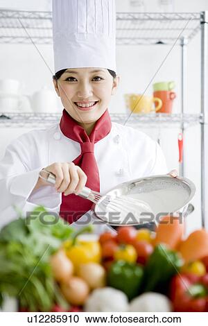 Chef whisking ingredients in a bowl behind a box of vegetables View Large Photo Image Stock Image - Chef whisking ingredients in a bowl behind a box of vegetables. Fotosearch
