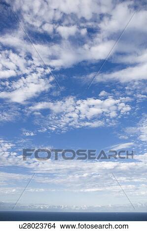 Picture - Clouds in blue sky over sea. Fotosearch