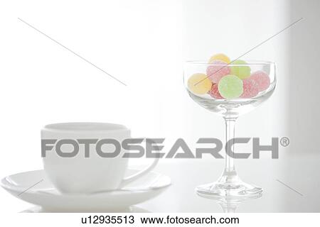 Stock Image - Coffee cup and a glass of candy. Fotosearch