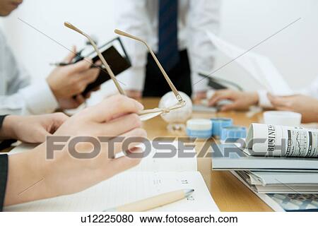 Stock Image - Colleagues working at desk in office. Fotosearch