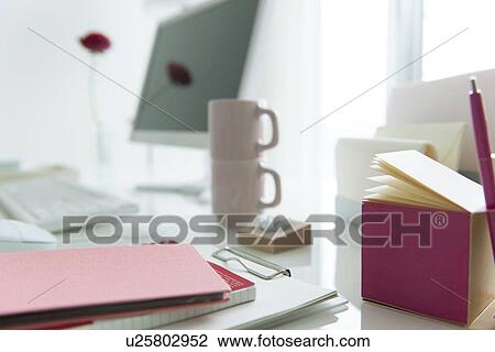 Stock Image - Computer desk with coffee cups and office stationery. Fotosearch