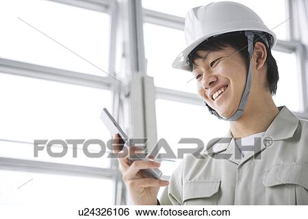 Construction worker using mobile phone View Large Photo Image Stock Photograph - Construction worker using mobile phone. Fotosearch