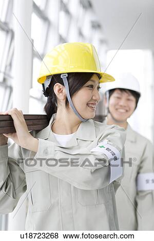 Stock Photo - Construction workers carrying wooden planks. Fotosearch