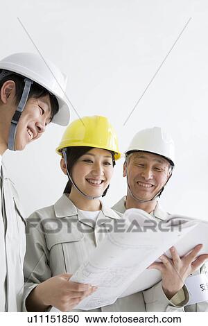 Construction workers looking at blueprints View Large Photo Image Stock Image - Construction workers looking at blueprints. Fotosearch