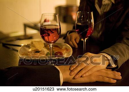 Couple holding hands over a table View Large Photo Image Stock Image - Couple holding hands over a table. Fotosearch