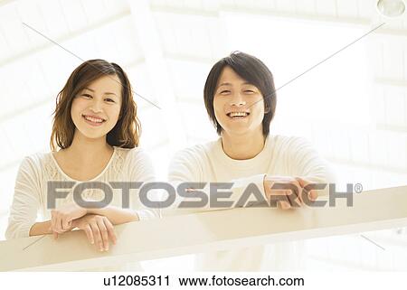 Couple leaning over railing View Large Photo Image Stock Image - Couple leaning over railing. Fotosearch