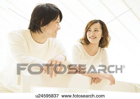 Stock Photo - Couple leaning over railing. Fotosearch