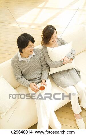 Couple relaxing on the sofa View Large Photo Image Picture - Couple relaxing on the sofa. Fotosearch