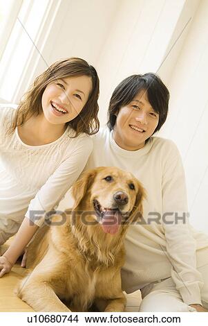 Couple sitting on the floor with their dog View Large Photo Image Picture - Couple sitting on the floor with their dog. Fotosearch