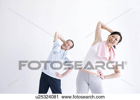 Stock Image - Couple stretching together. Fotosearch