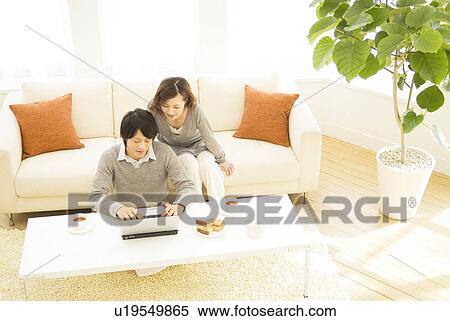 Couple using a laptop together View Large Photo Image Stock Photography - Couple using a laptop together. Fotosearch