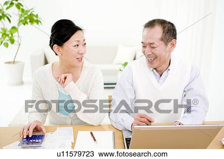 Stock Image - Couple working on their finances. Fotosearch