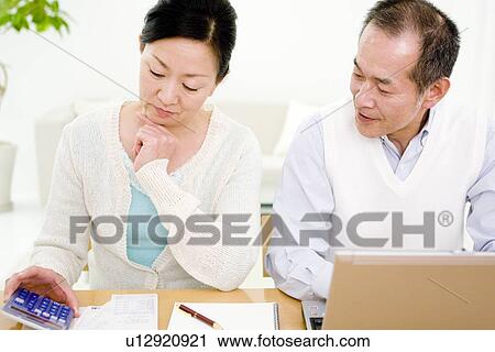 Stock Image - Couple working on their finances. Fotosearch